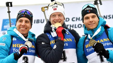 Le double tenant du titre de la Coupe du monde de biathlon, le Norvégien Johannes Boe, entouré ici des Français Quentin Fillon Maillet (à gauche) et Émilien Jacquelin (à droite). (MARCO BERTORELLO / AFP)