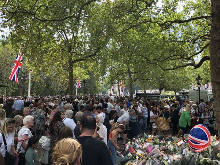 Des passants déposent des fleurs et viennent se recueillir aux abords de Buckingham Palace, à Londres, le 11 septembre 2022.&nbsp; (MARIE-ADELAIDE SCIGACZ / FRANCEINFO)