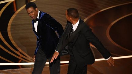 Le comédien Will Smith assène une gifle à l'humoriste Chris Rock sur la scène des Oscars,&nbsp;dimanche 27 mars 2022 à&nbsp;Hollywood (Etats-Unis). (ROBYN BECK / AFP)