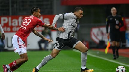 Le Parisien Kylian Mbappé (à droite) au duel avec le Brestois Noah Fadiga (à gauche), le 11 mars 2023. (LOIC VENANCE / AFP)