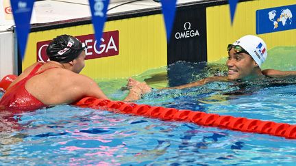 La française Analia Pigree (à droite), médaillée de bronze, félicite la Canadienne Kylie Masse, championne du monde sur le 50 mètres dos, à Budapest, le 22 juin 2022. (FRANCOIS-XAVIER MARIT / AFP)