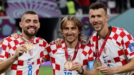 Mateo Kovacic, Luka Modric et Ivan Perisic posent avec leur médaille de bronze au Qatar, le 17 décembre 2022. (JACK GUEZ / AFP)