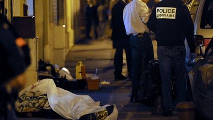 Policiers enquêtant près du corps de l'une des deux personnes tuées lors de la fusillade (AFP PHOTO - ANNE-CHRISTINE POUJOULAT)