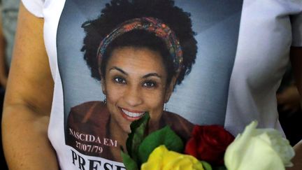 Une femme porte un tee-shirt en hommage à Marielle Franco lors d'une messe organisée à Rio de Janeiro un an après sa mort, le 14 mars 2019.&nbsp; (SERGIO MORAES / REUTERS)