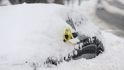 Une voiture abandonnée presque entièrement recouverte de neige à Buffalo, dans l'Etat de New York, le 26 décembre 2022. (JOHN NORMILE / GETTY IMAGES NORTH AMERICA / AFP)