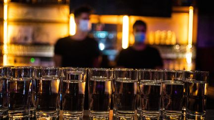 Deux barmans avec des masques sanitaires derriere le bar du Divan du monde à Paris le 8 juillet 2021. (XOSE BOUZAS / HANS LUCAS)