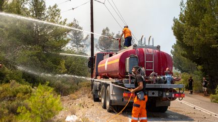 Des pompiers tentent d'éteindre un incendie de forêt à Vati, sur l'île de Rhodes, en Grèce, le 26 juillet 2023. (DAMIANIDIS ELEFTHERIOS / ANADOLU AGENCY / AFP)