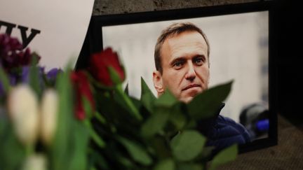 Des photos d'Alexeï Navalny et des fleurs sont déposées devant l'ambassade de Russie à Londres le 16 février 2024. (DANIEL LEAL / AFP)