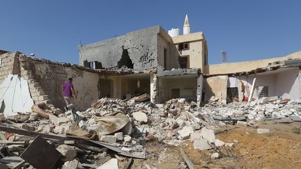 Un Libyen fouille les décombres d'une maison après une frappe aérienne qui a tué trois enfants et fait plusieurs blessés dans la banlieue sud de Tripoli le 14 octobre 2019. (MAHMUD TURKIA / AFP)