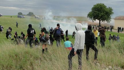 Bloqués par plusieurs gendarmes mobiles à la sortie du village de Saudron (Haute-Marne), des opposants au projet Cigéo ont monté une rapide barricade quand d’autres sont allés dans le champ d’à côté, le 16 août 2016. Avec les premiers jets de grenades lacrymogènes.&nbsp; (MAXPPP)