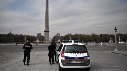 Des policiers sur la place de la Concorde, à Paris, en plein confinement, le 17 mars 2020. (LIONEL BONAVENTURE / AFP)