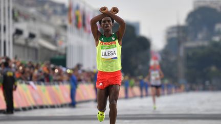 L'Ethiopien&nbsp;Feyisa Lilesa franchit la ligne d'arrivée du marathon aux Jeux olympiques de Rio (Brésil), le 21 août 2016. (OLIVIER MORIN / AFP)