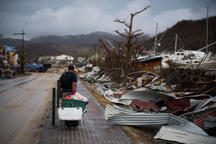 Un pêcheur transporte son matériel, après avoir perdu son bateau lors du passage de l'ouragan Irma, le 9 septembre 2017, au Marigot, sur l'île de Saint-Martin. (MARTIN BUREAU / AFP)