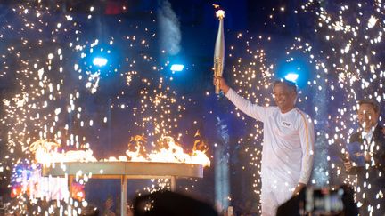 Après une virée par l'avenue des Champs-Elysées, l'Assemblée nationale, la place Vendôme ou encore le musée du Louvre, la flamme olympique termine son périple du 14 juillet à l’Hôtel de Ville. Et c'est Yannick Noah qui a l'honneur d'allumer le chaudron. (CLAIRE SERIE / HANS LUCAS / AFP)