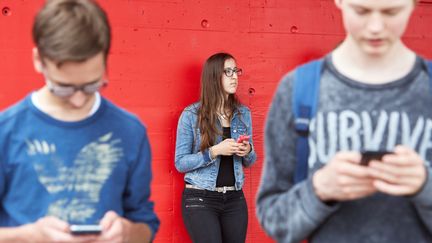 Des adolescents avec leurs smartphones à Zug en Suisse. Image d'illustration. (MAXPPP)