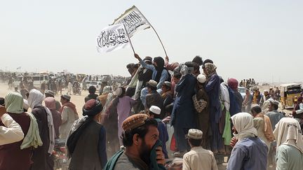 Des manifestants brandissent le drapeau des talibans, en Afghanistan, le 14 juillet 2021.&nbsp; (ASGHAR ACHAKZAI / AFP)