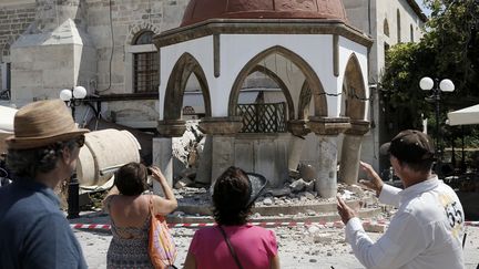 Des touristes regardent la mosquée Defterdar sur l'île de Kos (Grèce), le 12 juillet 2017. (COSTAS BALTAS / REUTERS)