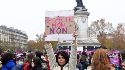 Une femme brandit une pancarte lors d'une manifestation contre les violences sexuelles et sexistes, à Paris, le 20 novembre 2021. (ALAIN JOCARD / AFP)