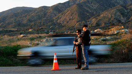 Des policiers bloquent la route qui m&egrave;ne au chalet o&ugrave; s'est barricad&eacute; Christopher Dorner, le 12 f&eacute;vrier 2013. (KEVORK DJANSEZIAN / GETTY IMAGES NORTH AMERICA)