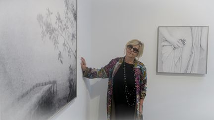 La photographe Flore devant ses œuvres à la galerie Clémentine de la Féronnière. (CHRISTOPHE AIRAUD / FRANCEINFO CULTURE)