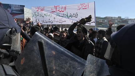 Des policiers anti-&eacute;meute afghans&nbsp;face &agrave; des manifestants qui protestent contre l'autodaf&eacute; d'exemplaires du Coran, &agrave; Kaboul (Afghanistan), le 23 f&eacute;vrier 2012.&nbsp; (SHAH MARAI / AFP)