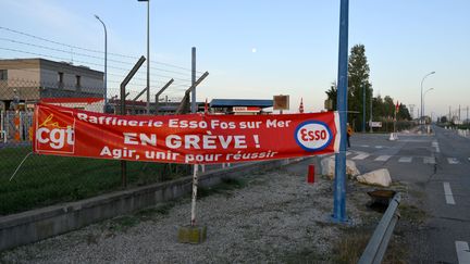 Une banderole syndicale installée par des salariés grévistes devant la raffinerie TotalEnergies de&nbsp;Fos-sur-Mer (Bouches-du-Rhône), mardi 11 octobre 2022. (NICOLAS TUCAT / AFP)