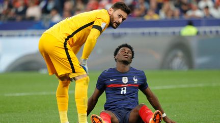 Le jeune milieu de terrain de l'équipe de France, Aurélien Tchouameni, avec son capitaine Hugo Lloris, le 3 juin 2022. (GEOFFROY VAN DER HASSELT / AFP)