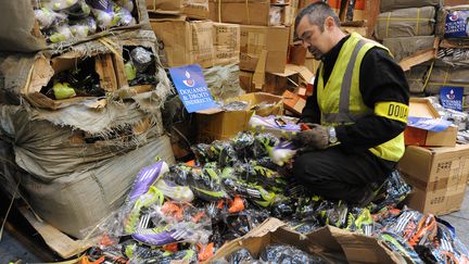 Un douanier contrôle des chaussures de sport issues d'une saisie, le 8 décembre 2011 dans un entrepôt à Epouville. (JEAN-FRANCOIS MONIER / AFP)