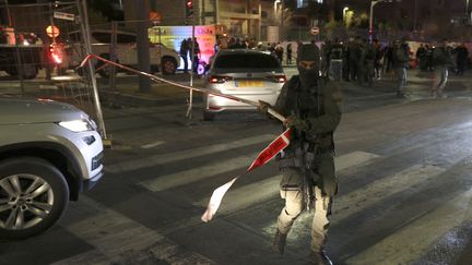 Les forces de sécurité israéliennes sur le site d'une fusillade qui a fait au moins sept morts dans un quartier de colons de Jérusalem-Est annexé par Israël, le 27 janvier 2023. (AHMAD GHARABLI / AFP)