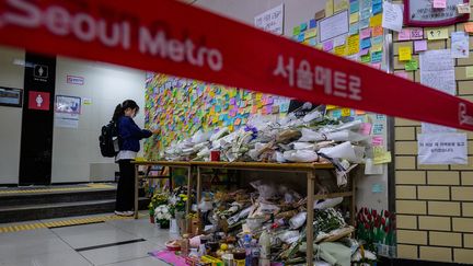 Une femme prie en mémoire de la victime sur les lieux du crime, à la station de métro Sindang, à Séoul. (ANTHONY WALLACE / AFP)