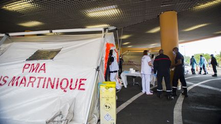 Des pompiers et des urgentistes devant une tente de tri mise en place pour les patients Covid en détresse respiratoire, à l'hôpital Pierre Zobda-Quitman, le CHU de Fort-de-France, le 30 juillet 2021. Seulement 15% des habitants du territoire caribéen de Martinique sont vaccinés. Un nouveau confinement de 3 semaines a été décrété depuis ce 30 juillet. (LIONEL CHAMOISEAU / AFP)