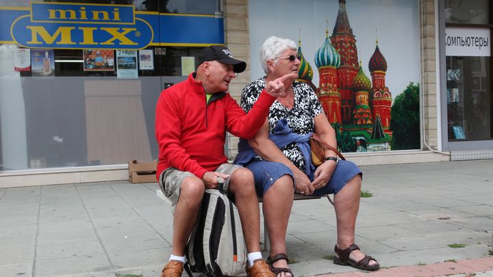 Un couple de Britanniques, en vacances &agrave; Chypre, est assis devant un supermarch&eacute; russe, le 19 mars 2013, &agrave; Limassol. (BARBARA LABORDE / AFP)