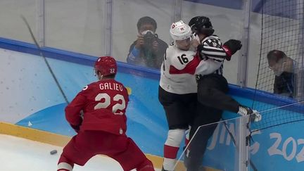 Le hockeyeur suisse Raphael Diaz propulse l'arbitre de la rencontre Comité olympique de Russie - Suisse contre le plexiglas, mercredi 9 février. (FRANCETVSPORT)