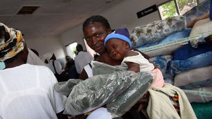 Une femme et sa fille reçoivent des moustiquaires, dans un hôpital du district de Gutu, au Zimbabwe. Illustration.&nbsp; (ALEXANDER JOE / AFP)