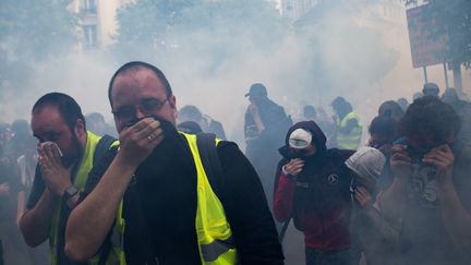 Gilets jaunes et autres manifestants du 1er mai 2019 victimes de&nbsp;gaz lacrymogènes, à Paris. Le long du cortège, des incidents entre la police et des black-blocks ont perturbé la manifestation entre Montparnasse et la place d'Italie. (EMERIC FOHLEN / NURPHOTO / AFP)