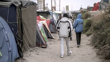 Des migrants marchent dans la "jungle" de Calais (Pas-de-Calais), le 7 octobre 2016. (PHILIPPE HUGUEN / AFP)