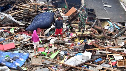 Des personnes observent les dégâts dans le village de&nbsp;Sumber Jaya (Indonésie), le 25 décembre 2018, trois jours après le passage dévastateur d'un tsunami lié à une éruption volcanique.&nbsp; (ADEK BERRY / AFP)