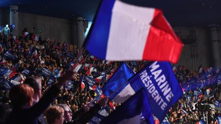 Drapeaux et banderoles brandis lors d'un meeting de la candidate du Front national Marine Le Pen, le 26 mars 2017 à Lille (Nord). (ALAIN JOCARD / AFP)