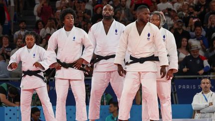 Les judokas tricolores Sarah-Léonie Cysique, Teddy Riner, Maxime-Gaël Ngayap Hambou, Romane Dicko et Marie-Eve Gahié avant leur demi-finale face à l'Italie lors de l'épreuve par équipes mixtes aux JO de Paris 2024, le samedi 3 août 2024. (JACK GUEZ / AFP)