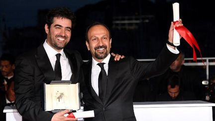 Le comédien Shahab Hosseini ( à gauche) et le cinéaste Asghar Farhadi posent avec leurs prix respectifs (interprétation masculine et scénario) après la cérémonie de clôture du Festival de Cannes dimanche 22 mai 2016.  (MUSTAFA YALCIN / ANADOLU AGENCY)