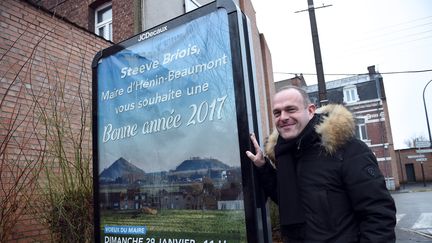 Le maire FN Steeve Briois pose à côté d'une affiche, le 30 janvier 2016 à Hénin-Beaumont (Pas-de-Calais). (FRANCOIS LO PRESTI / AFP)