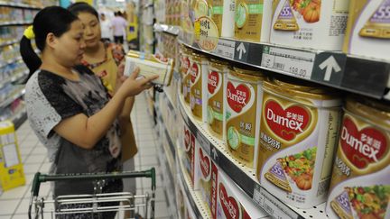 Une employ&eacute;e aide une cliente &agrave; choisir du lait en poudre Dumex, une marque du groupe Danone, le 5 ao&ucirc;t 2013 &agrave; Hefei (Chine). (JIANAN YU / REUTERS)