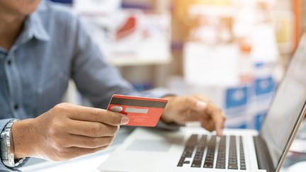 Homme entrant ses informations bancaires en ligne. (WITTHAYA PRASONGSIN / MOMENT RF / GETTY IMAGES)