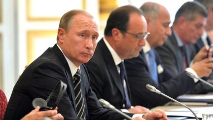 Le pr&eacute;sident russe Vladimir Poutine, le pr&eacute;sident fran&ccedil;ais&nbsp;Fran&ccedil;ois Hollande, et le ministre des Affaires &eacute;trang&egrave;res Laurent Fabius, &agrave; l'Elys&eacute;e, &agrave; Paris, lors d'un sommet consacr&eacute; &agrave; l'Ukraine, le 2 octobre 2015. (RUSSIAN PRESIDENTIAL PRESS AND I / ANADOLU AGENCY / AFP)