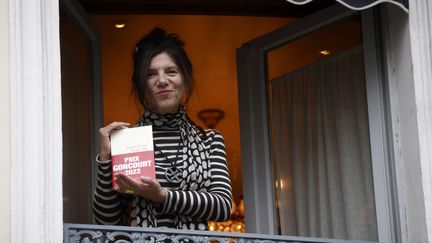 Brigitte Giraud tient son roman "Vivre Vite" (Flammarion) à la fenêtre du restaurant Drouant après avoir reçu le prestigieux prix Goncourt, à Paris, le 3 novembre 2022. (YOAN VALAT / EPA / MAXPPP)