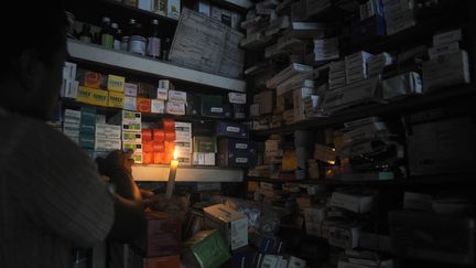 Un pharmacien &eacute;claire sa boutique &agrave; la bougie, le 31 juillet 2012 &agrave; Siliguri, dans le Bengale-Occidental&nbsp;(Inde). (DIPTENDU DUTTA / AFP)