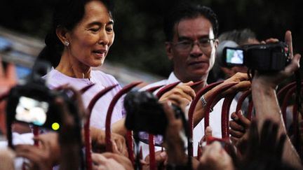 Aung San Suu Kyi apparaît à la grille de sa maison après l'annonce de sa libération (13 novembre 2010) (AFP)