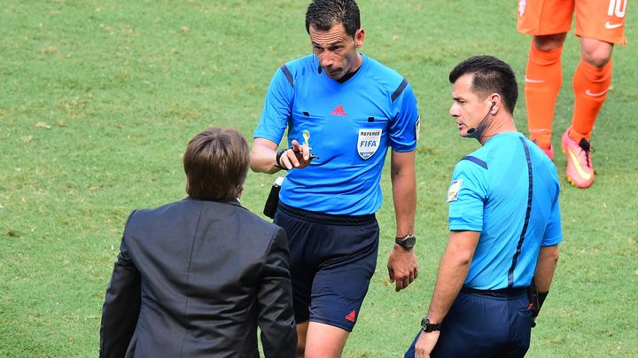 L'arbitre portugais Pedro Proen&ccedil;a recadre le s&eacute;lectionneur mexicain Miguel Herrera, le 29 juin 2014 lors du match Pays-Bas-Mexique, au stade Castelao de Fortaleza (Br&eacute;sil). (JAVIER SORIANO / AFP)