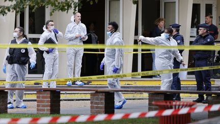 Des policiers et des enquêteurs devant l'entrée du lycée Gambetta à Arras, dans le Pas-de-Calais, où une attaque au couteau a fait un mort et trois blessés, le 13 octobre 2023. (LUDOVIC MARIN / POOL)