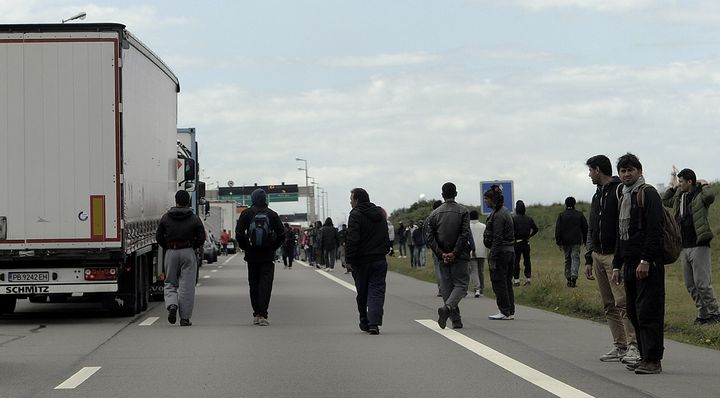 Des migrants profitent d'un embouteillage aux abords du port de Calais pour tenter de monter &agrave; bord de camions en partance pour l'Angleterre, le 20 mai 2015. (SARAH ALCALAY / SIPA)